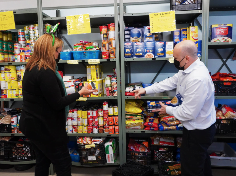 Engin Ogut and Lisa Conrad of Peerage Capital help stock up the food bank pantry. More pictures can be seen in their story.
